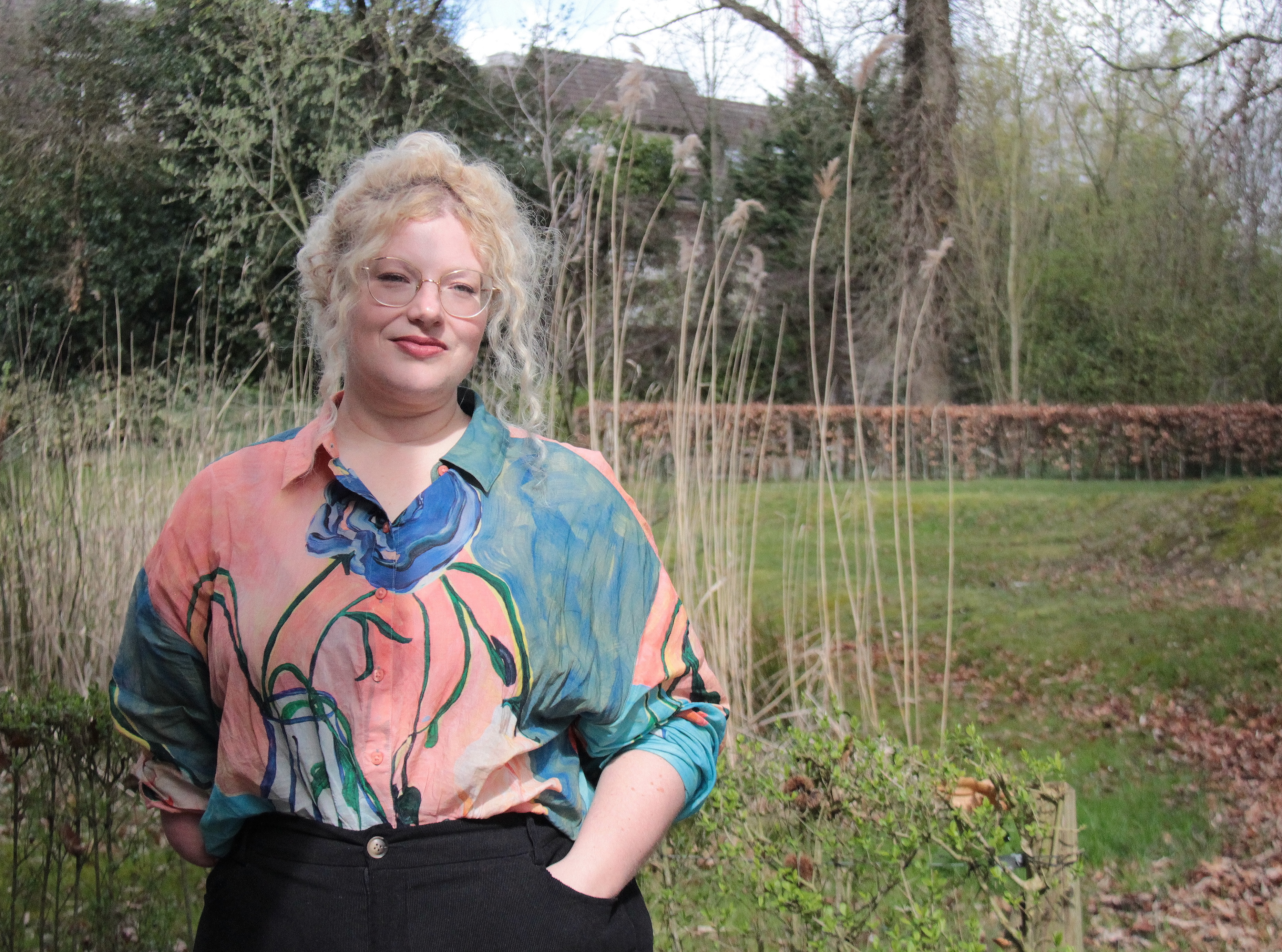 Anaïs van Ertvelde met een tuin op de achtergrond.